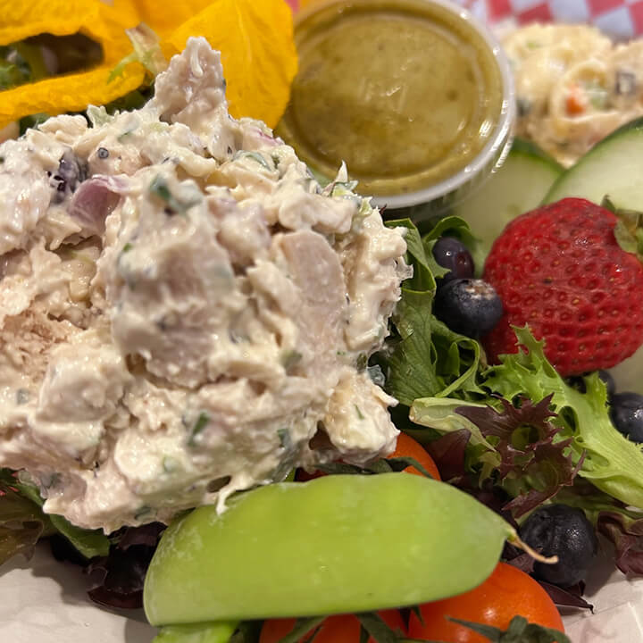 Shows the chicken salad featured in the Fruity Clucker sandwich on a salad